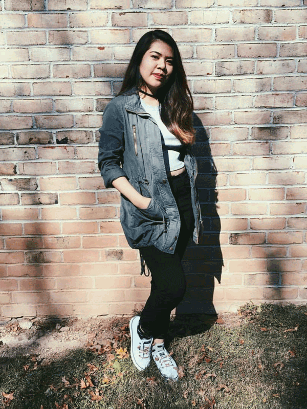 Pauline standing behind a walll of bricks