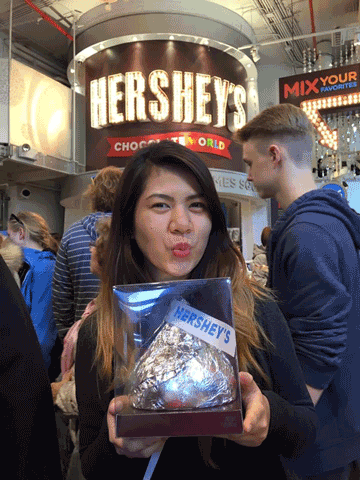 Pauline holding a giant kisses choco making a kissing gesture